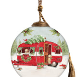 Festive glass ornament featuring a red Christmas camper with two puppies, a snow-covered tree on top, and holiday decorations in a wintry scene.