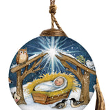 Nativity scene glass ornament with baby Jesus in a manger, Star of Bethlehem shining, and woodland animals surrounding the peaceful scene.