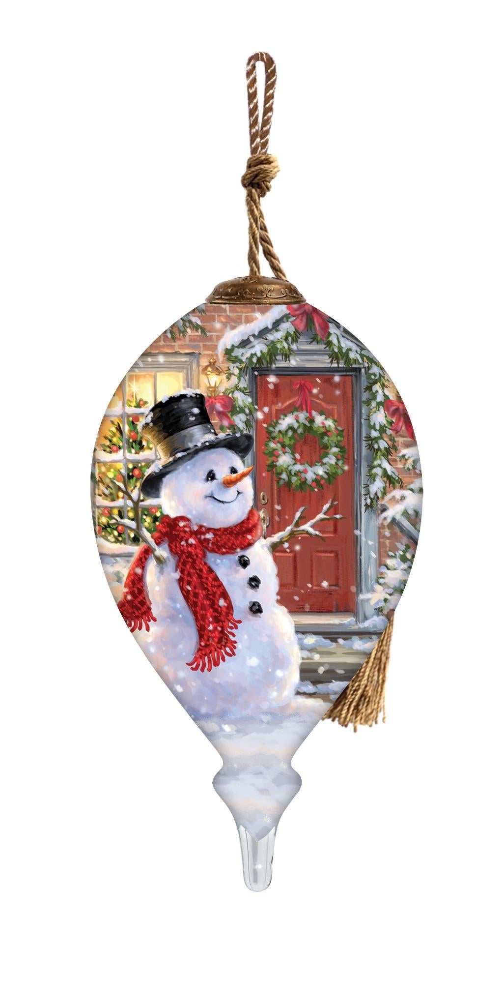 Hand-painted glass ornament featuring a snowman with a top hat and red scarf standing in front of a festive holiday door with a wreath.