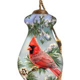 Hand-painted glass ornament featuring a red cardinal perched in frosty pine branches with snow-covered pinecones.