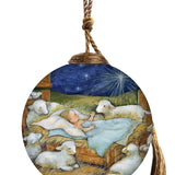Glass ornament depicting baby Jesus sleeping in a manger, surrounded by lambs under a glowing star in a peaceful nativity scene.