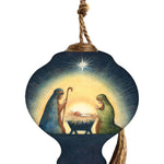 Hand-painted glass ornament depicting the Nativity scene with Mary, Joseph, and baby Jesus under a shining star in a peaceful, radiant setting.