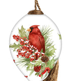 Hand-painted glass ornament featuring a red cardinal perched on festive greenery with holly, berries, and pinecones.